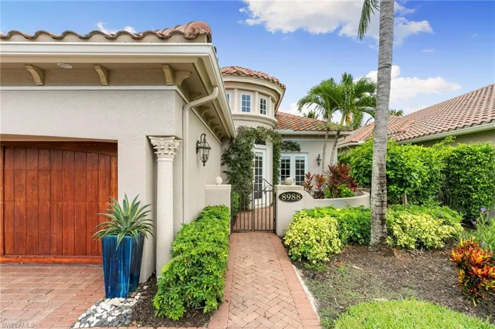 Doorway to property featuring a gate, stucco siding, and a tiled roof
