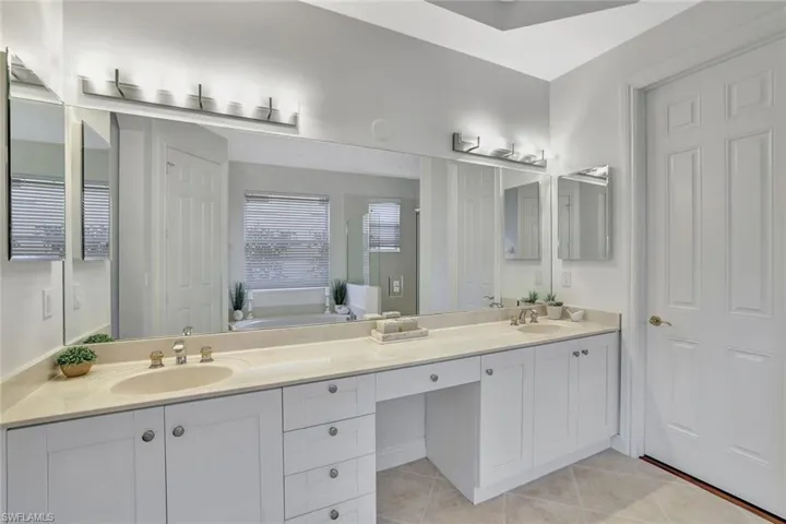Full bathroom with double vanity, a bath, and light tile patterned floors