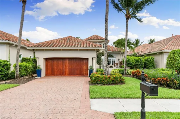 Mediterranean / spanish home with stucco siding, a front yard, driveway, an attached garage, and a tiled roof