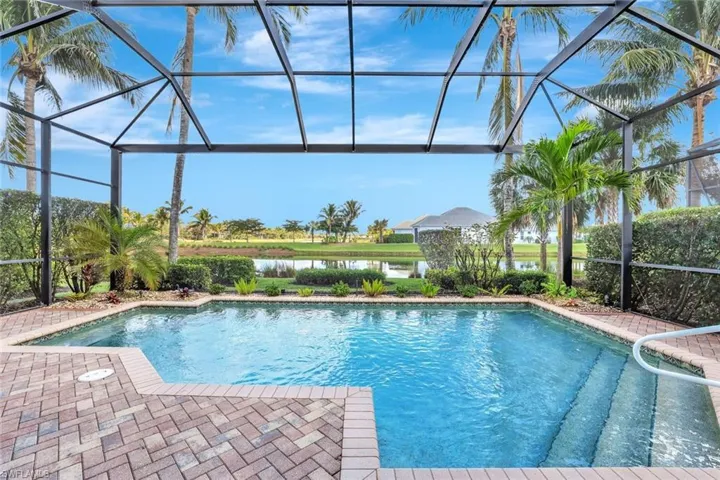 Outdoor pool with a sunroom, glass enclosure, a water view, and a patio