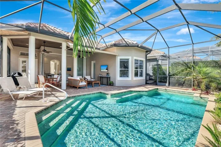 Swimming pool featuring glass enclosure, a sunroom, ceiling fan, a patio, and outdoor lounge area
