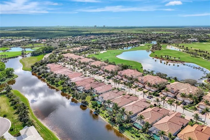 Aerial perspective of suburban area featuring a local golf course and a large body of water