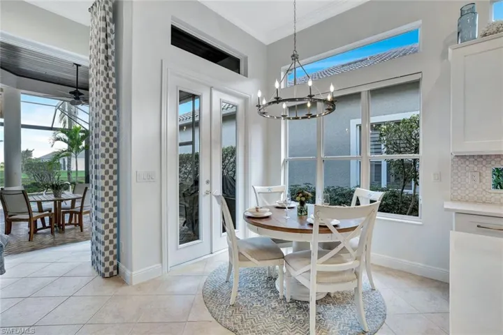Dining space with ornamental molding, french doors, plenty of natural light, light tile patterned floors, and ceiling fan