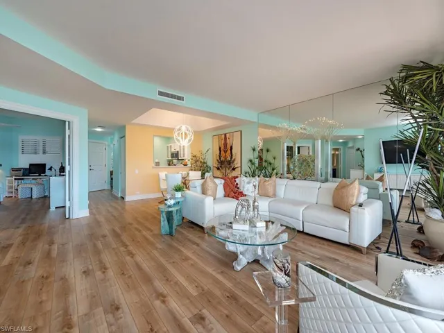 Living room with light wood-style floors, an office area, and a chandelier