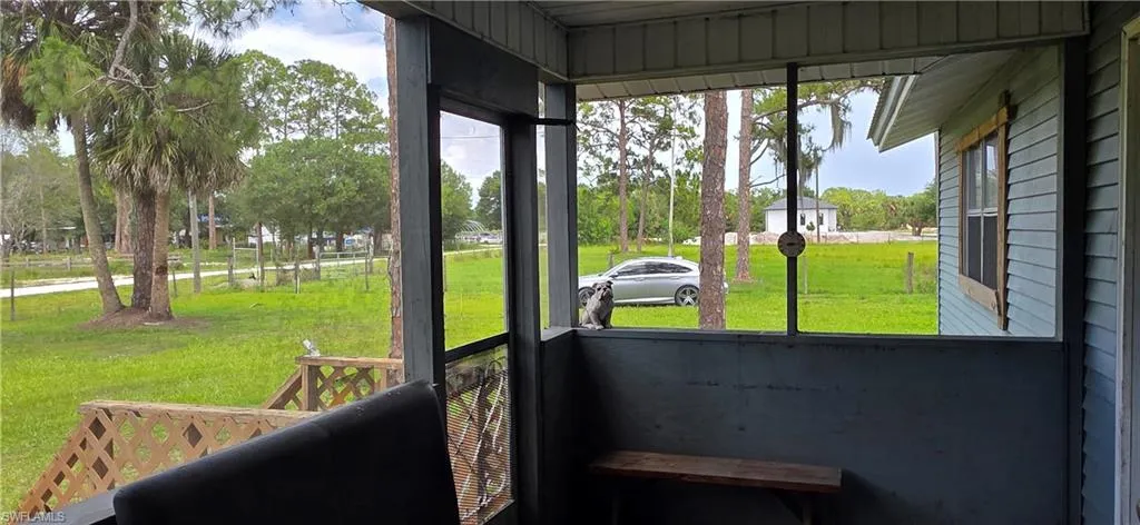 Screened porch with wooden railings and a built-in wooden bench