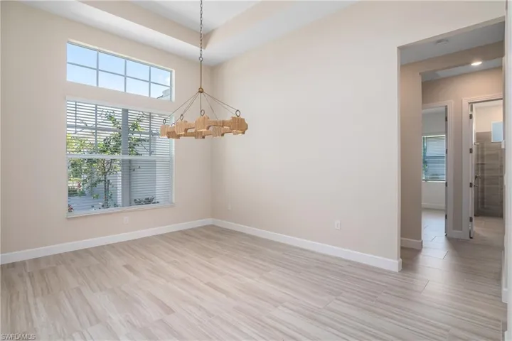 Spare room with a tray ceiling and an inviting chandelier