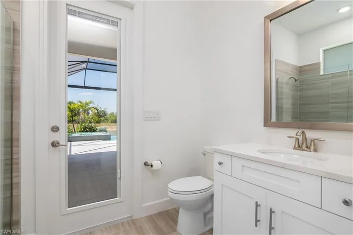 Bathroom featuring a shower with door, toilet, and oversized vanity