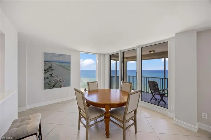 Dining room with plenty of natural light, light tile patterned flooring, expansive windows, and a water view