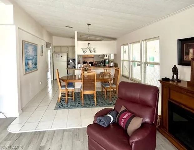 Dining room with lofted ceiling, light tile patterned floors, and a fireplace