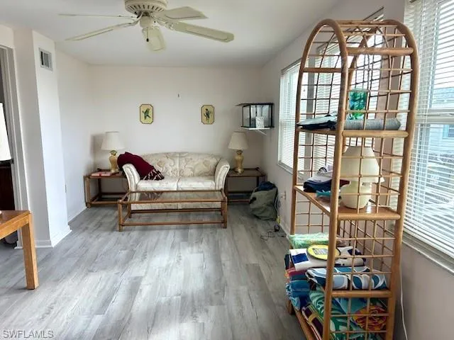 Living area featuring plenty of natural light, wood finished floors, and ceiling fan