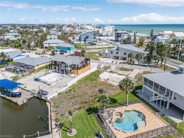 Drone / aerial view of a nearby body of water and a pool