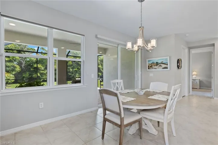 Dining room featuring baseboards, a notable chandelier, and light tile patterned floors