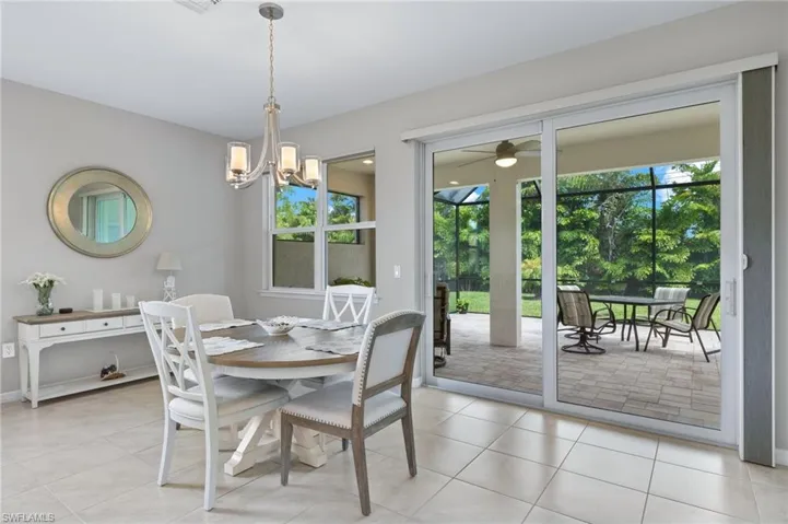 Dining room featuring ceiling fan with notable chandelier and light tile patterned floors