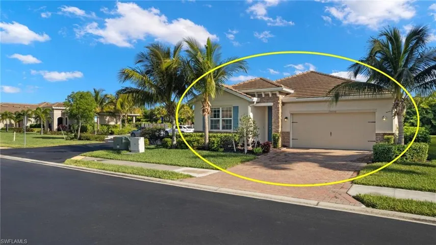 View of front of home with a tile roof, decorative driveway, a front lawn, a garage, and stucco siding