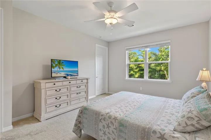 Bedroom with baseboards, a ceiling fan, visible vents, and light carpet