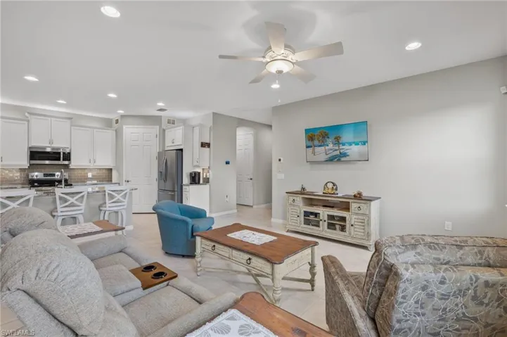 Living area featuring recessed lighting, a ceiling fan, baseboards, and light tile patterned flooring