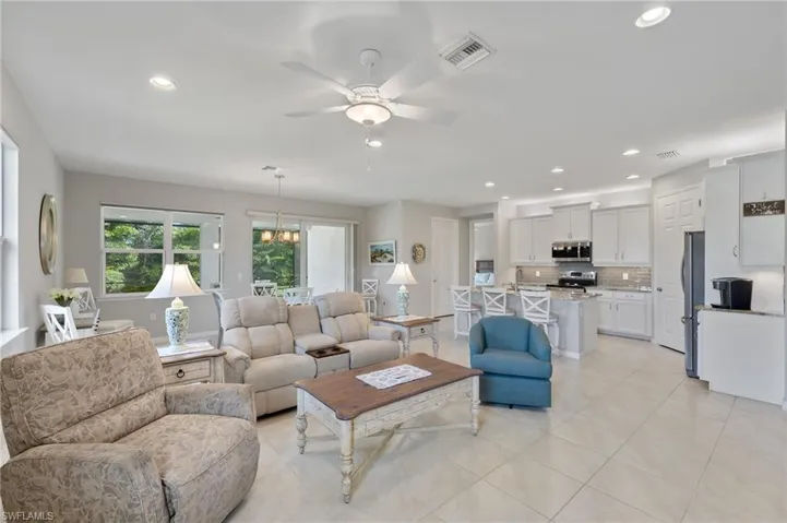 Living area with a ceiling fan, light tile patterned flooring, visible vents, and recessed lighting