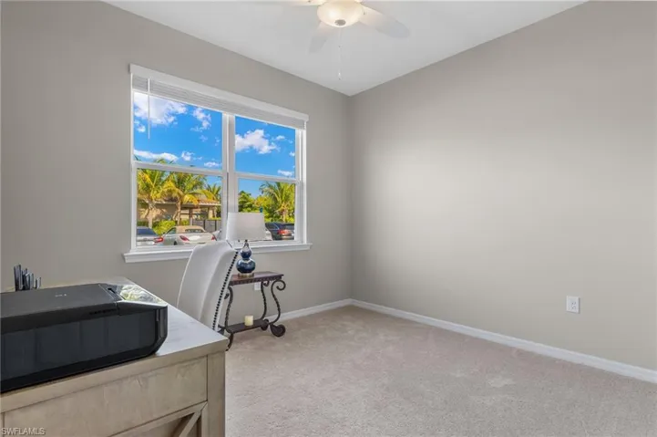 Home office featuring baseboards, a ceiling fan, and carpet flooring