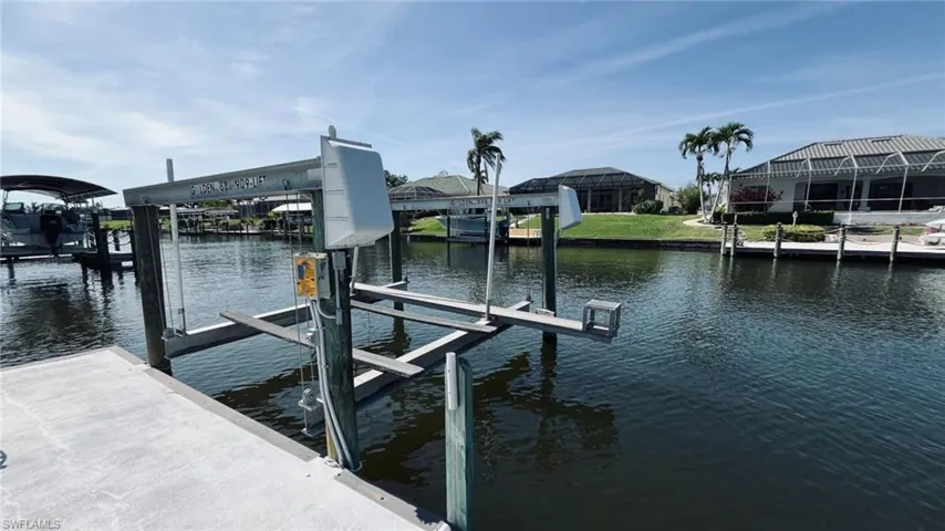 Private dock featuring a concrete platform, pilings, and a boat lift