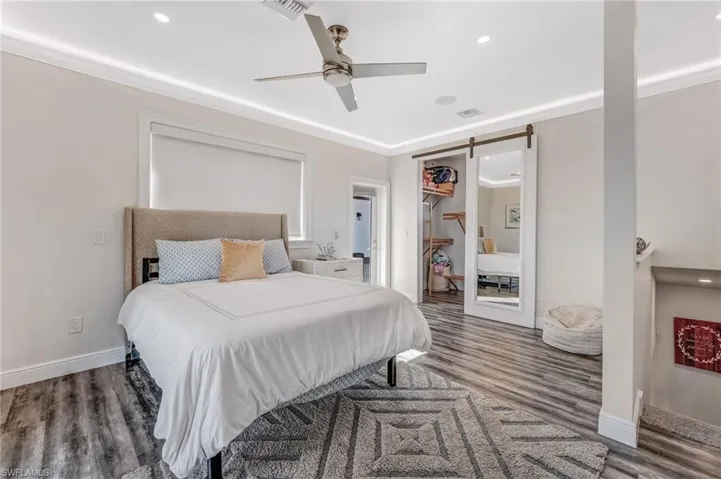The 4th bedroom is situated on the second level above the casita and features a walk-in closet with a stylish barn door, along with access to a private upstairs lanai.