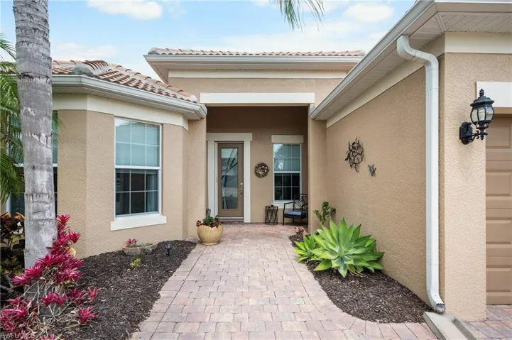 Stucco exterior with a tile roof and decorative sconce lighting
