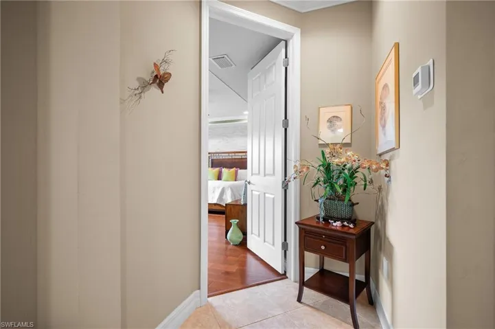 Warm beige wall tones complement the neutral-toned floor tile in this hallway space