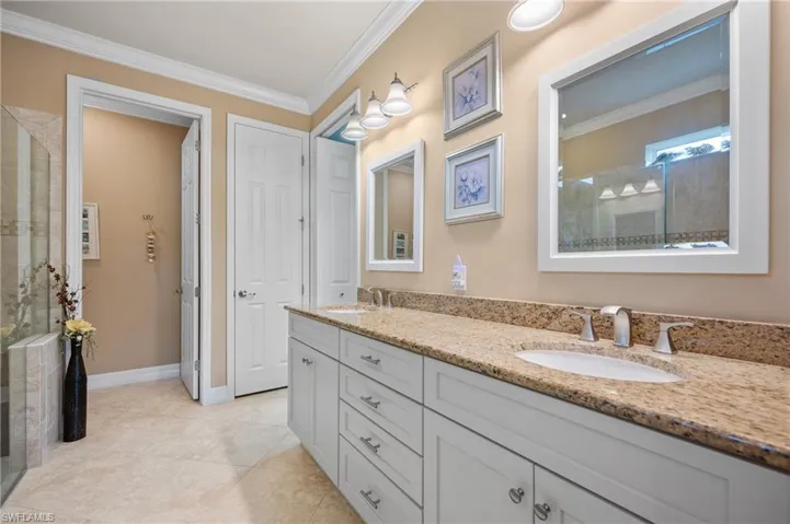 Dual vanity with a stone countertop, under-mount sinks, and brushed nickel hardware