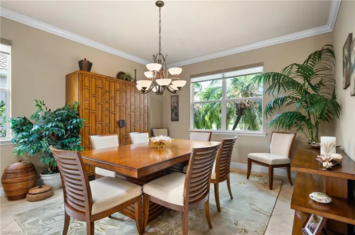 Dining area featuring crown molding, a large picture window, an elegant chandelier, and tile flooring