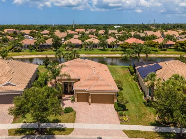 Mediterranean-style residence featuring a tile roof, paver driveway, and a two-car garage
