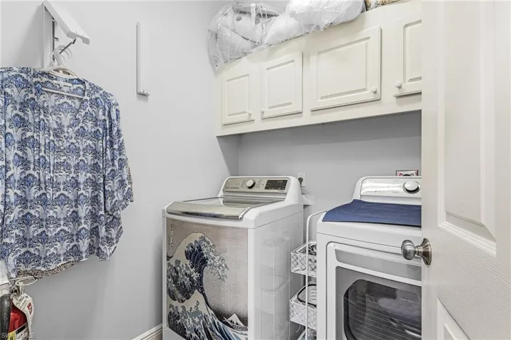 Washroom featuring washing machine and dryer and cabinet space