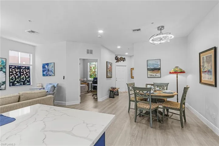 Dining room with light wood-style flooring, baseboards, recessed lighting, and a chandelier