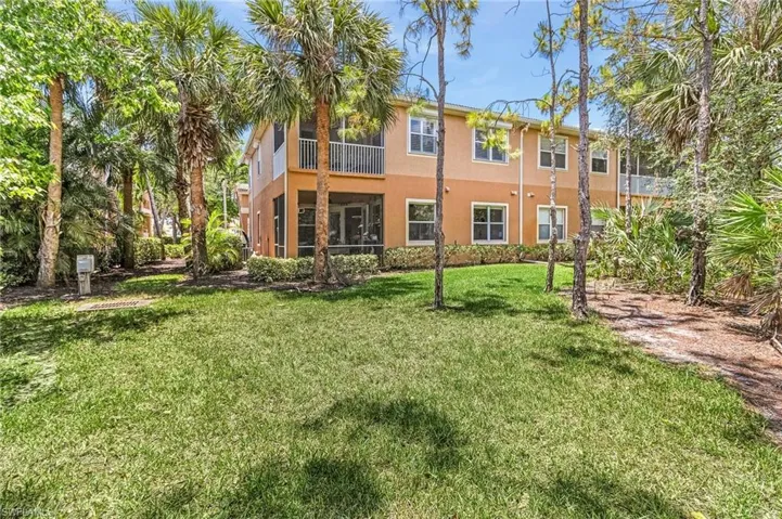 Back of property with stucco siding and a lawn