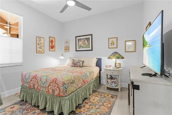 Bedroom with light wood-type flooring, baseboards, and a ceiling fan