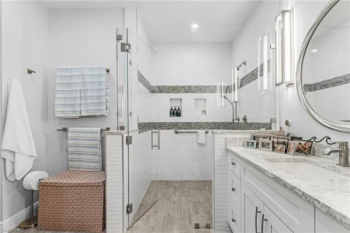 Full bathroom with vanity, a stall shower, and recessed lighting