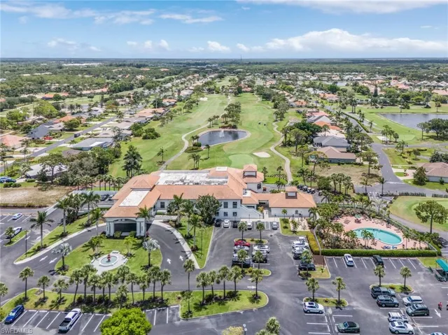 Aerial view of property and surrounding area with a large body of water, a golf club, and nearby suburban area