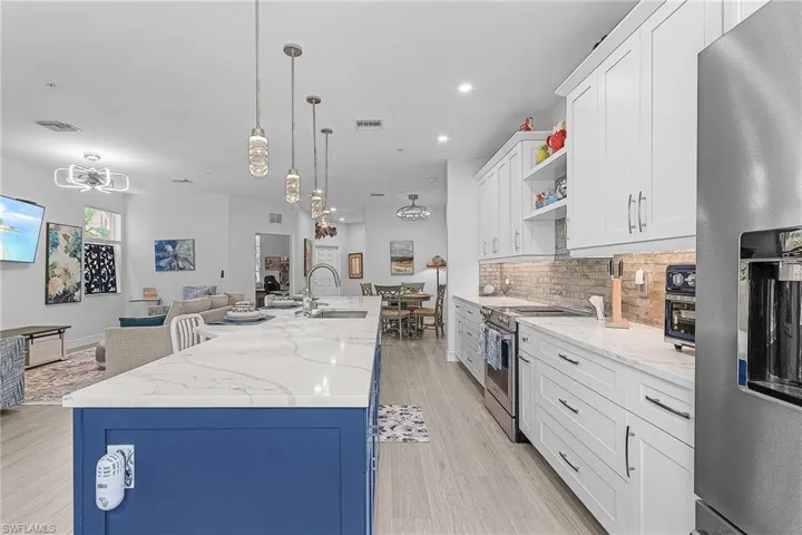Kitchen featuring appliances with stainless steel finishes, a sink, a chandelier, open floor plan, and recessed lighting
