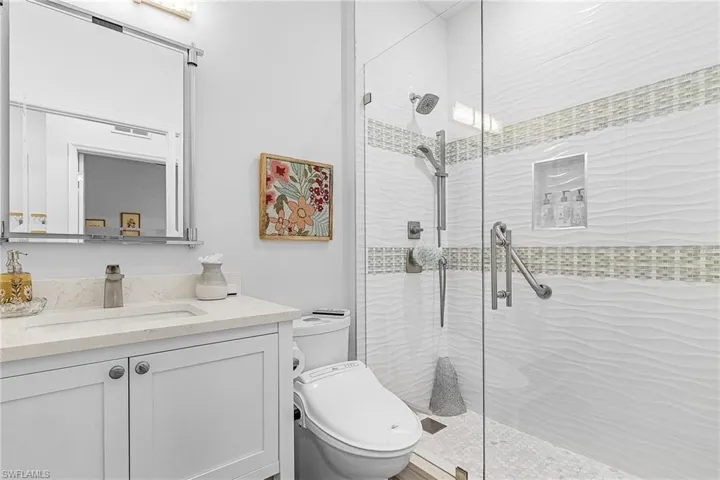 Full bathroom with a shower stall, toilet, and vanity