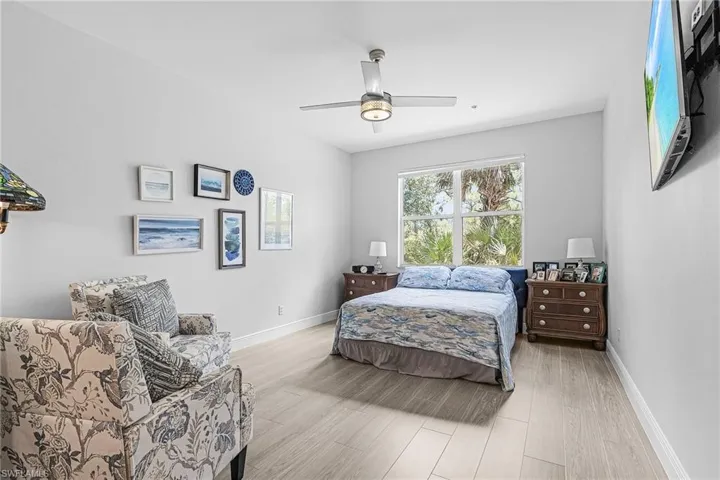 Bedroom with light wood-style flooring, baseboards, and a ceiling fan
