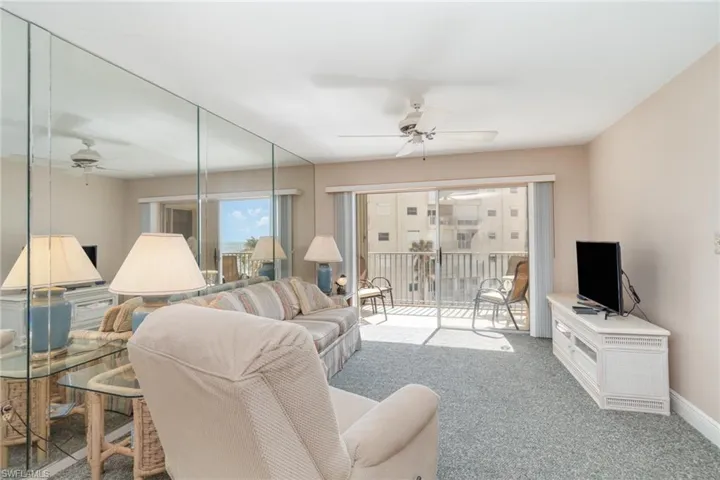 Carpeted living room featuring ceiling fan