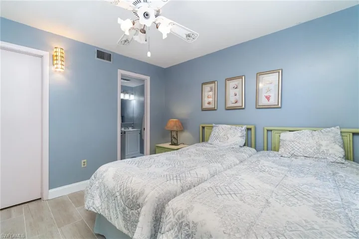 Bedroom #2 with light wood-style Tile  flooring and ceiling fan
