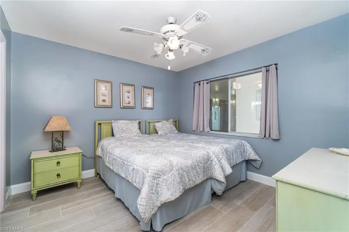 Bedroom #2 with light wood-style Tile  flooring and ceiling fan
