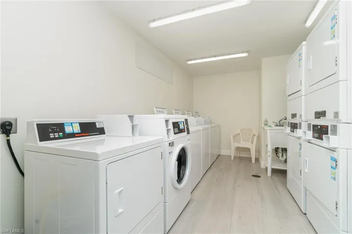 Washroom with stacked washer / dryer, light hardwood / wood-style flooring, and independent washer and dryer