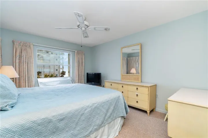 Carpeted bedroom featuring ceiling fan and partial view of Gulf