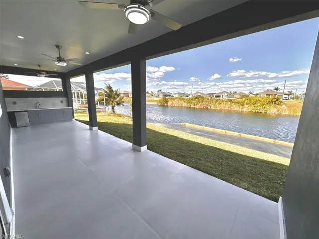View of patio / terrace with a water view, ceiling fan, and sink