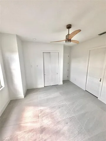 Unfurnished bedroom with a textured ceiling and ceiling fan