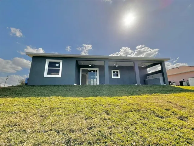 View of front of home featuring a front yard and ceiling fan