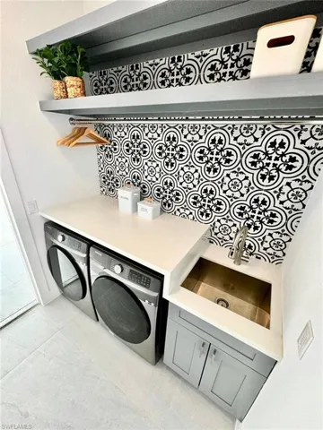 Clothes washing area featuring independent washer and dryer and sink
