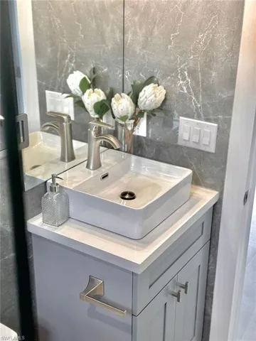 Bathroom featuring vanity and tasteful backsplash