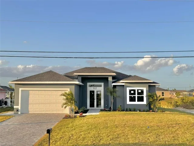 Prairie-style home featuring a front lawn and a garage