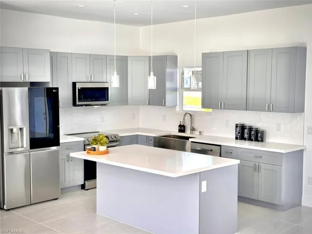 Kitchen featuring sink, a center island, stainless steel appliances, and backsplash